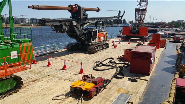 Timbermat's 200mm x 6m FSC certified wooden ground protection mats used to stabilise a construction platform on a barge at London City Airport, supporting heavy machinery during a waterfront project.