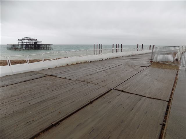 Temporary wooden walkway along a seafront, demonstrating Timbermat's expertise in creating safe and durable access paths over challenging terrain.